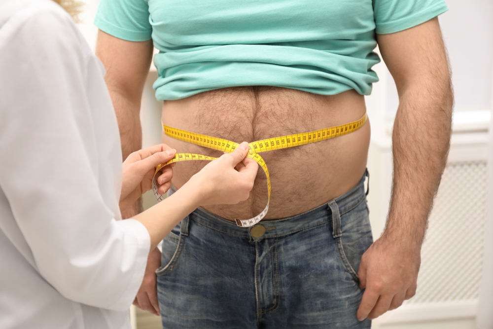 Doctor,Measuring,Overweight,Man's,Waist,In,Hospital,,Closeup